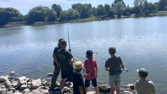 Kinder und Vereinsmitglieder beobachten am Silbersee den Drill eines Fisches direkt vor dem Ufer