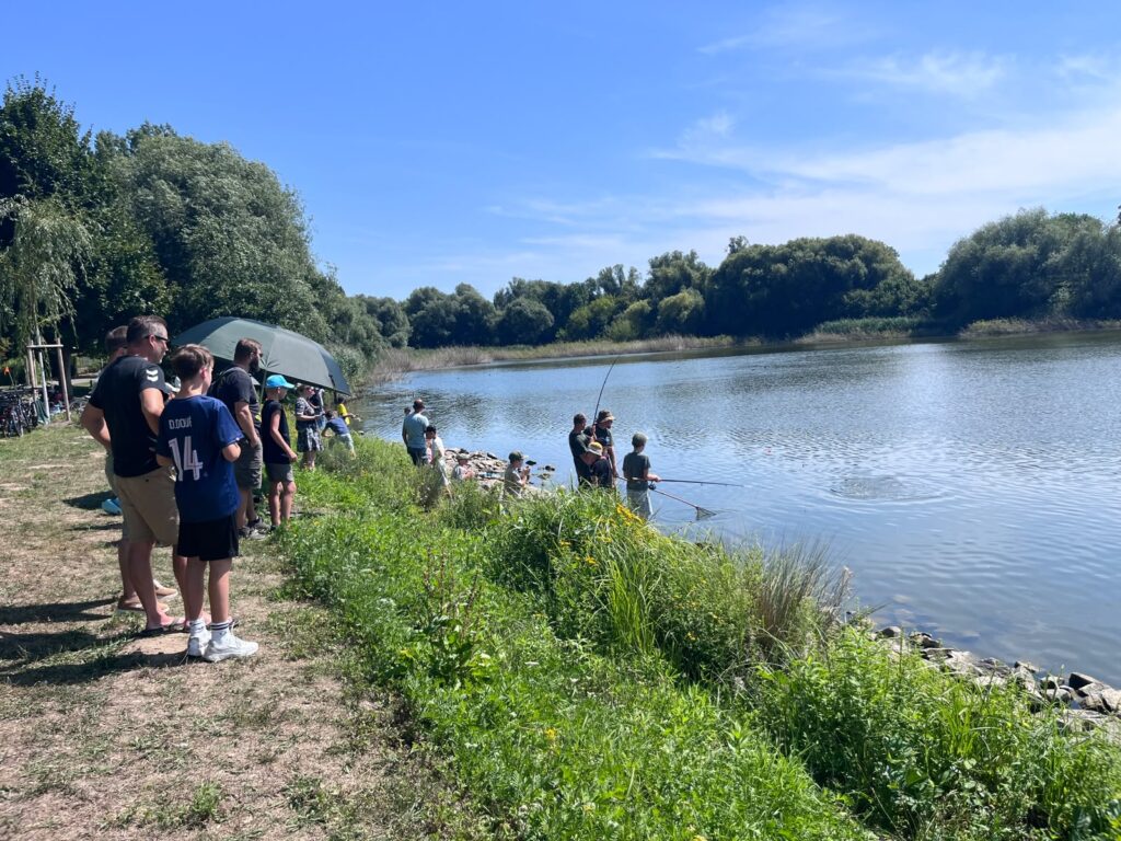 Kinder angeln beim Schnupperangeln am Ufer des Silbersees, Eltern schauen zu