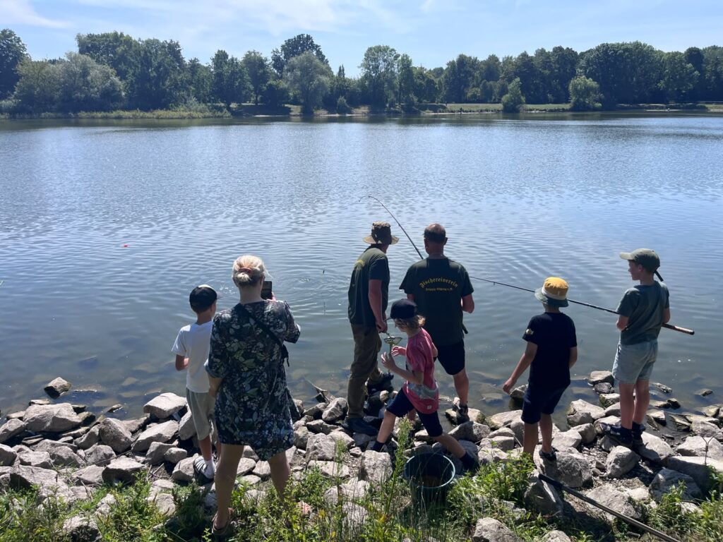 Kinder und Helfer des Fischereivereins am steinigen Ufer des Silbersees